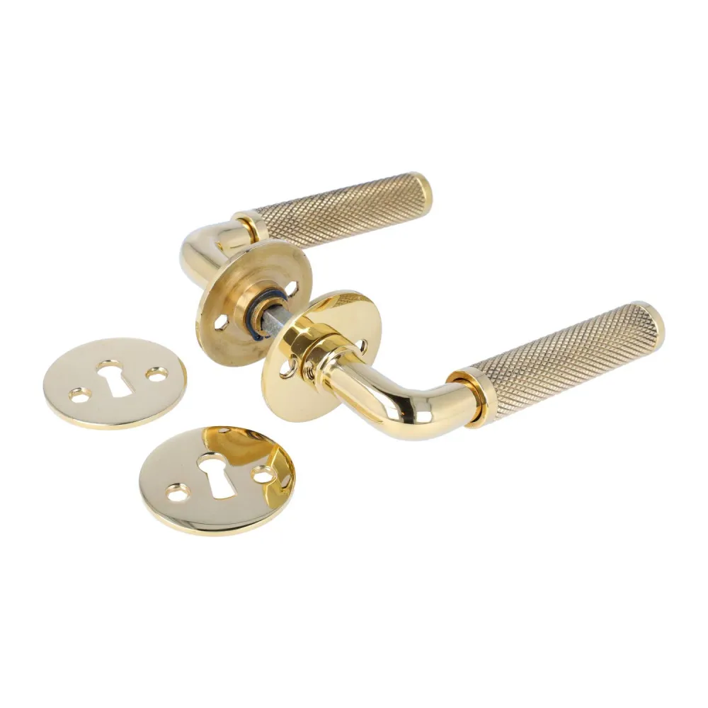 Funkis Nox dörrhandtag i blank golden metal med diamantslipat mönster, inkl. rosett och nyckelplatta